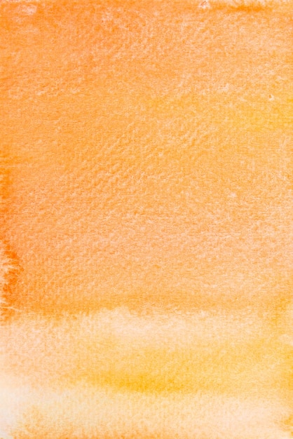 写真 紙の背景にオレンジと黄色の水彩画を手で描く