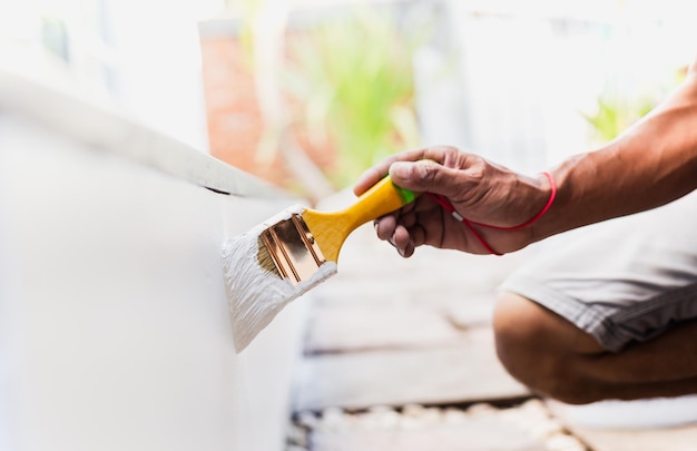 Hand painting outside wall with white color