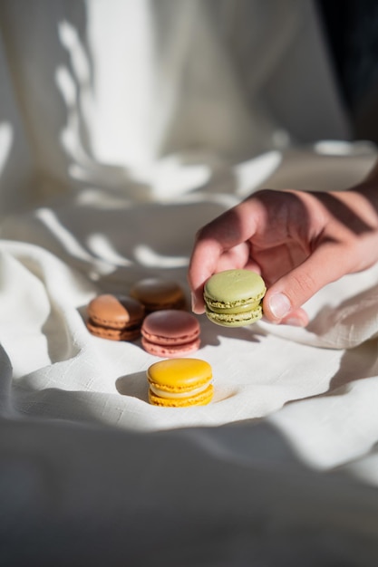 Foto hand pakt een groene macaron verticale afbeelding