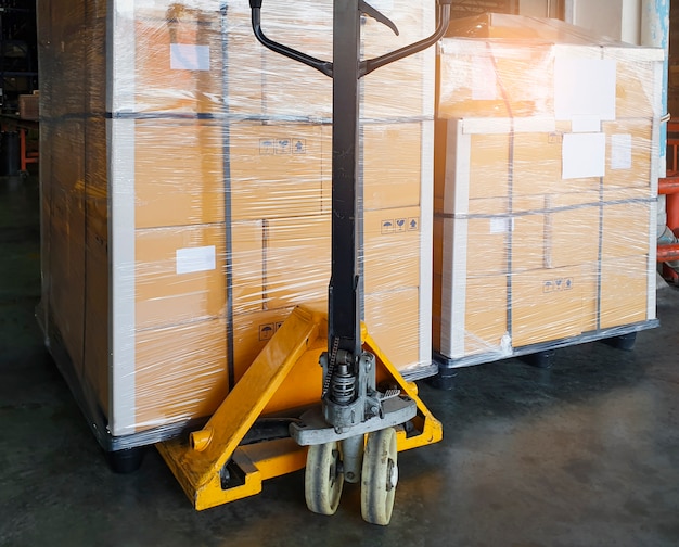 Hand pallet truck with cargo pallet shipment at the\
warehousing.