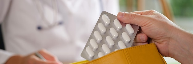 Hand of patient holds blister with medical pill and bag prescribing drugs and instructions for