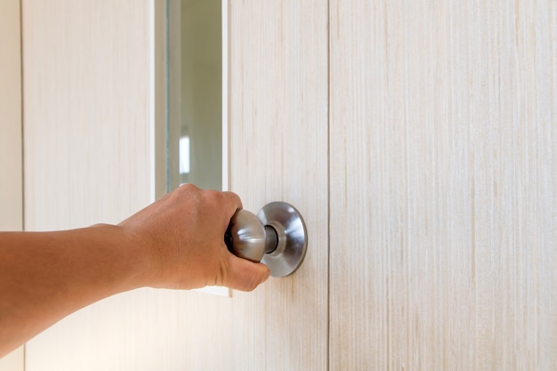 La mano della gente apre la porta verso l'interno, la porta esterna aperta si apre alla porta principale