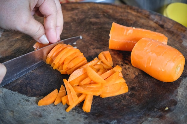 Foto la mano di una persona che sta tagliando le verdure