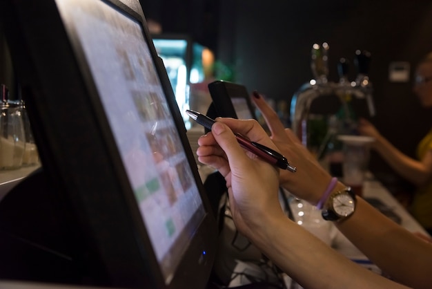 The hand of a person working with a touch screen monitor