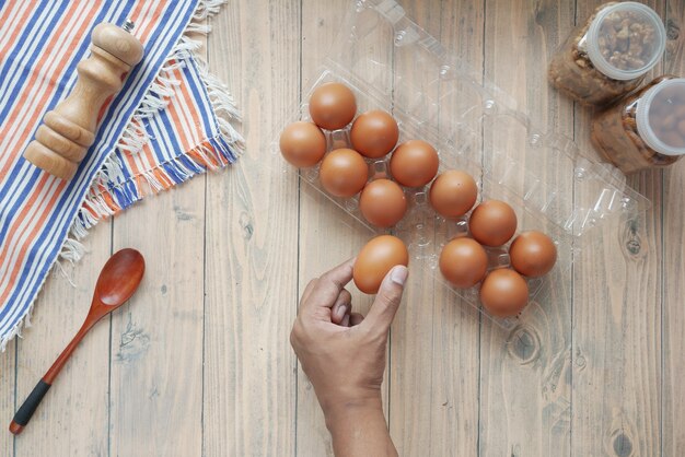 Hand pick eggs from a plastic case on table