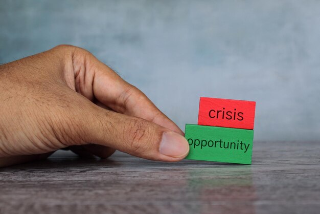 Foto cubo di legno a mano con testo opportunità su crisi concetto di business