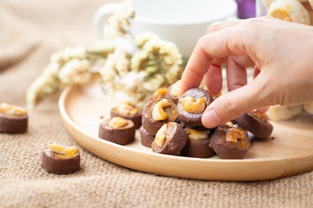 Hand picking chocolate Cookies Singapore or cashew Cookies with dried vintage flower 