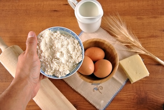 Hand picking eggs and flour for cooking