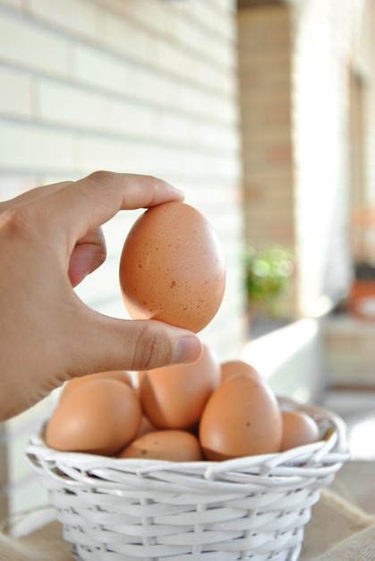 Hand picking up a basket egg white wicker