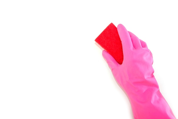 Рука в розовой перчатке держит кухонную губку на белом фоне. Скопируйте пространство.