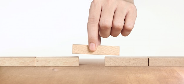 Hand placing a wooden block, Planning of project management in business