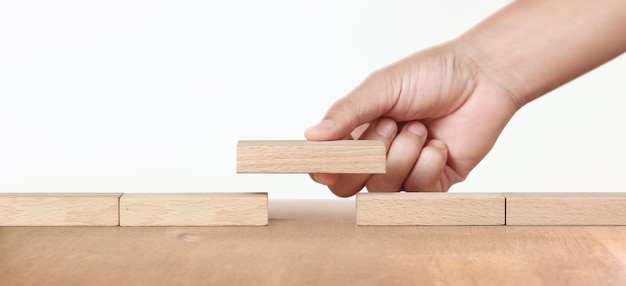 Hand placing a wooden block, Planning of project management in business