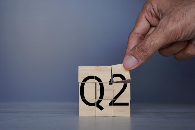 Ручное размещение деревянного куба с текстом Q2 Бизнес-концепция второго квартала
