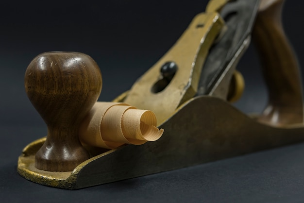 Hand plane on a black background. shavings