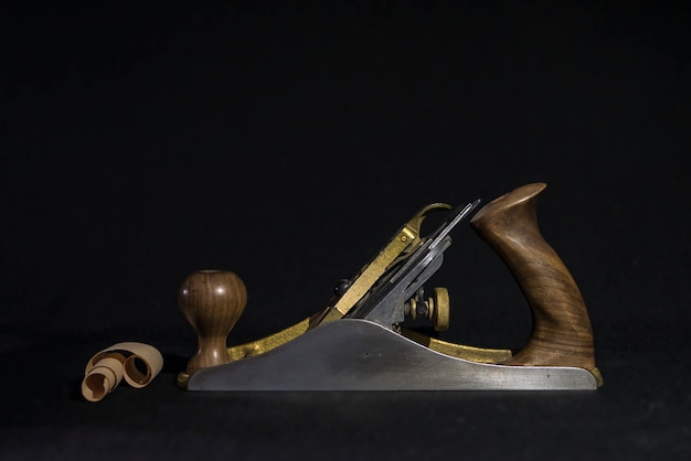 Photo hand plane on a black background. shavings