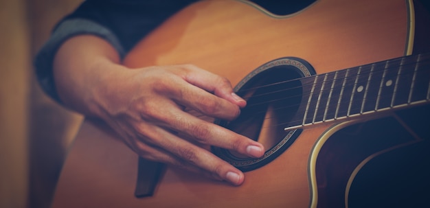 hand playing acoustic guitar