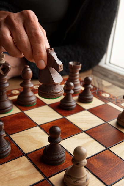 Hand playing chess on classic board