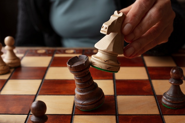 Photo hand playing chess on classic board