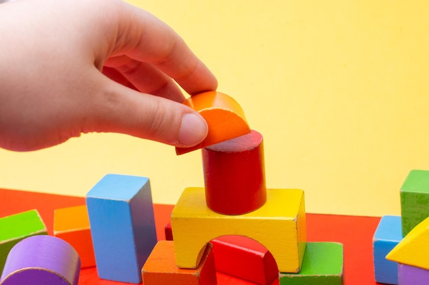 カラフルなおもちゃのブロックで遊ぶ手 教育的で創造的なおもちゃ