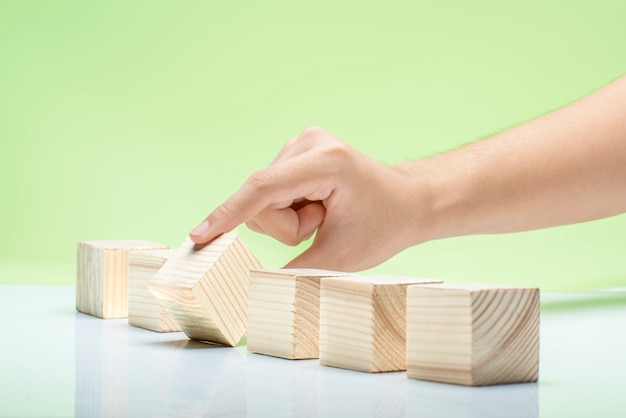 Hand playing with wooden block on the table