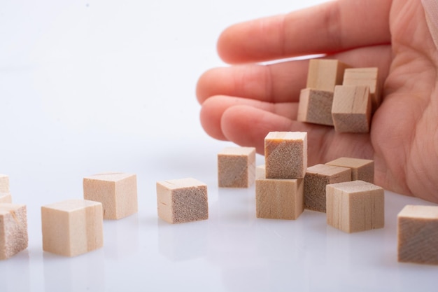 教育とビジネスのコンセプトとして木製の立方体で遊ぶ手