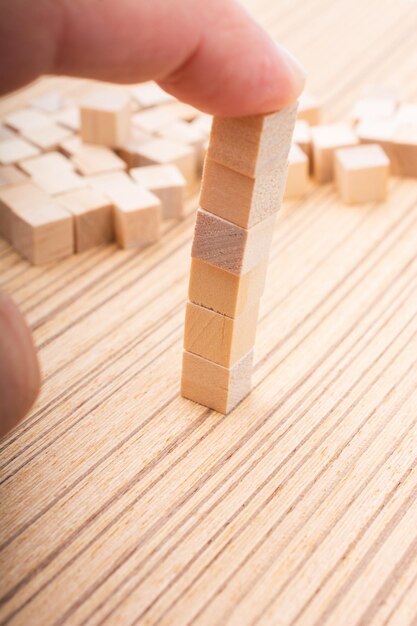 Hand playing with wooden toy cubes as educational games