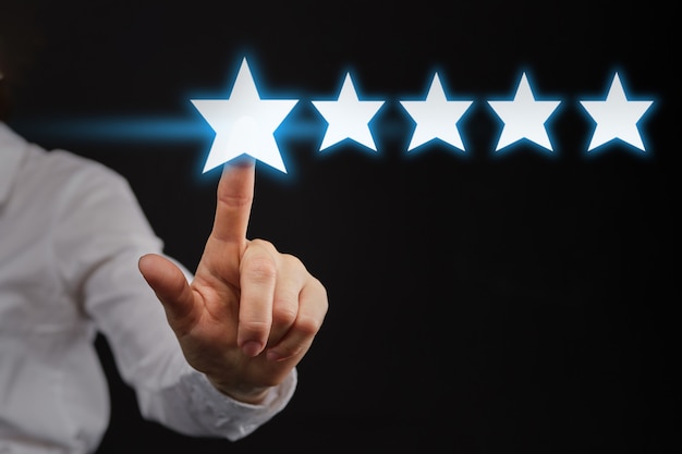 Photo the hand points to five 5 stars as a concept of top rating or rating.