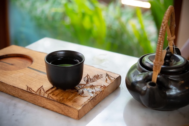 土鍋から中国または日本の伝統的なお茶を手で注ぐ