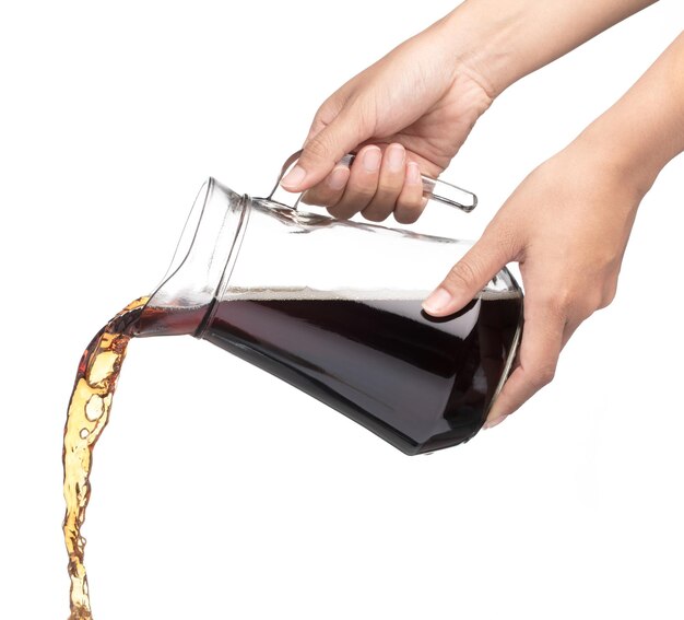 Photo hand pouring cola in a jug isolated on a white background