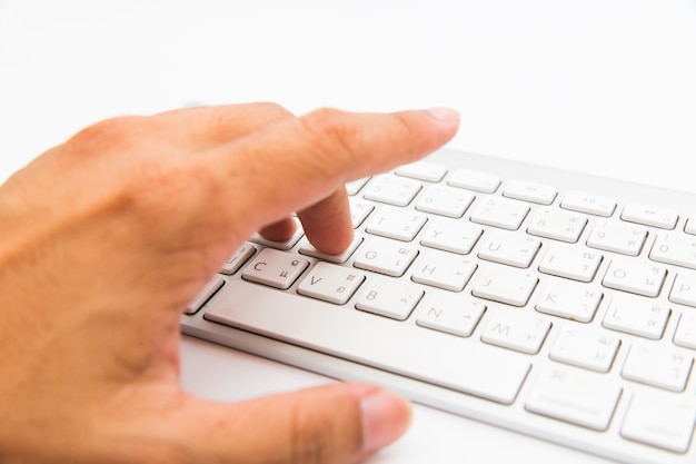 Photo hand press button on computer keyboard on white isolated