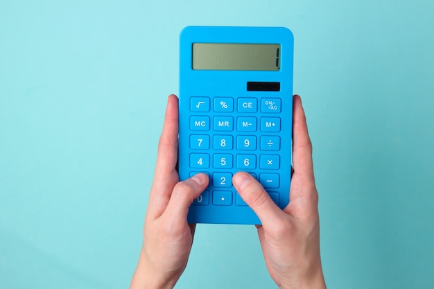 The hand presses the buttons blue calculator on blue.