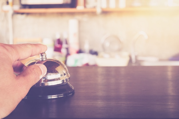 Hand Pressing A Service Bell call service on Coffee cafe or restaurant Counter Close up