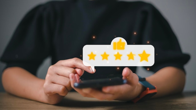 Hand pressing on smartphone screen with gold five star rating feedback icon and press level excellent rank for giving best score point to review the service business concept