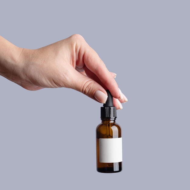 hand product and serum with a woman in studio on a gray background to promote an antiaging treatment skincare beauty and bottle with a female model mockup