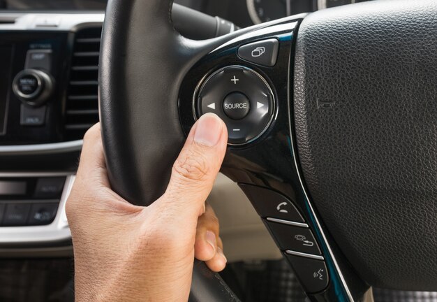 hand pushes the cruise control button on a steering