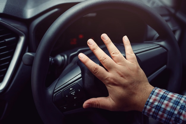 Photo hand pushing horn while driving