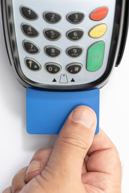 Photo hand put credit card into payment terminal on white background