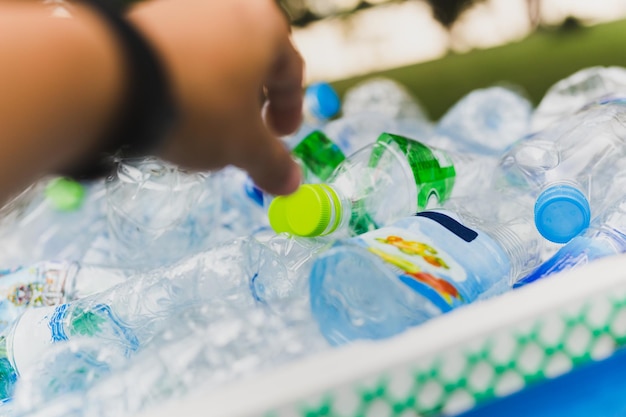 Hand put plastic bottles in to recycle garbage