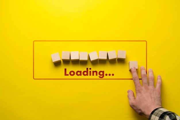 Photo a hand put a wooden cube in a row loading progress bar