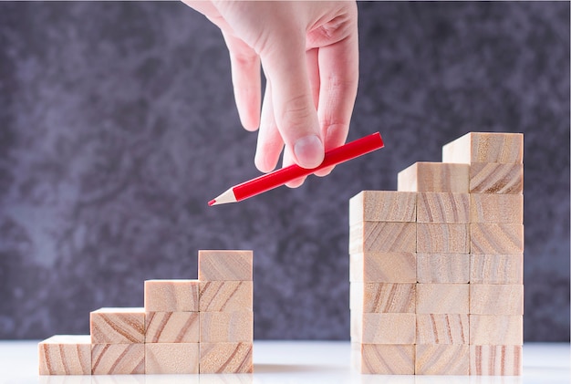 Hand puts a pencil on the missing rungs of the stairs