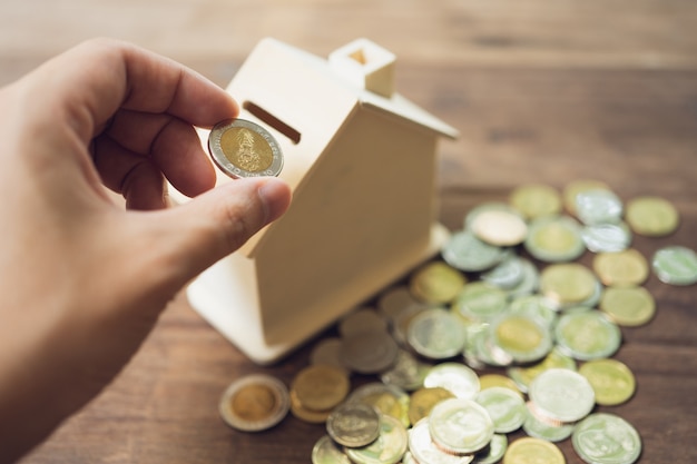 hand putting coin inside money box