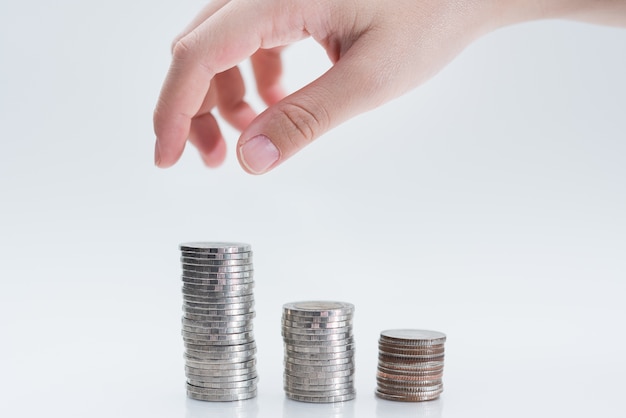 Hand putting coin on white background, Saving money