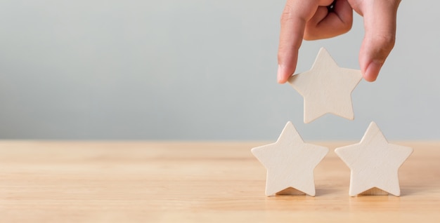 Hand putting wooden five star shape on table