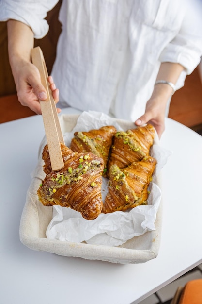 Hand reaching for croissant in basket with wooden spikes