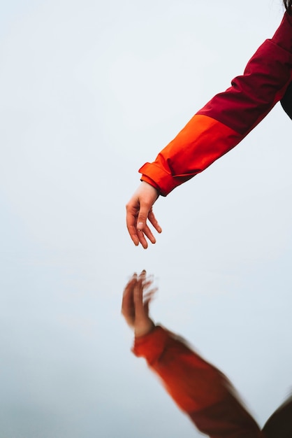 Hand reaching to the water below