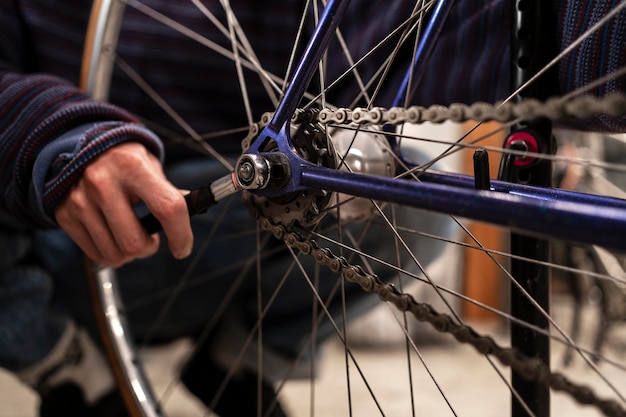 Hand repairing bike with wrench close up