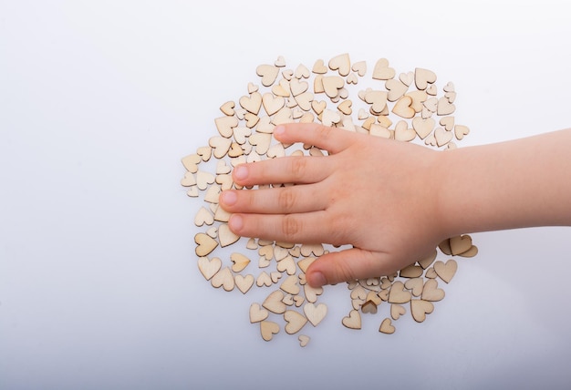 Hand over retro style wooden hearts on white background