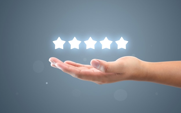 顧客のフィードバックを手作業で評価する5つ星のサービスランキング評価率の最高の製品品質またはユーザーエクスペリエンス投票の背景での満足度と優れたビジネスの成功