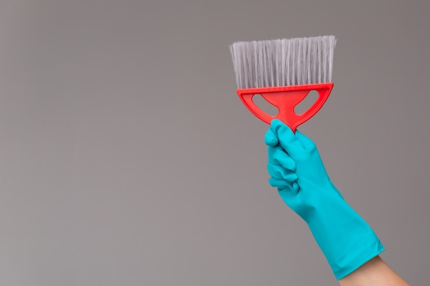 A hand in a rubber glove holds a panicle