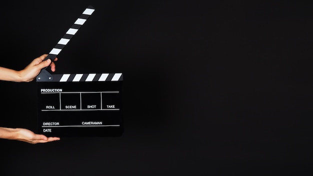 Hand's holding Clapperboard or movie slate use in video production ,film, cinema industry on black background.